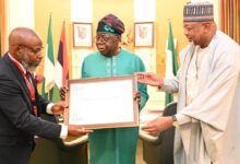 Prof. Adenle (l) presenting the award to President Tinubu